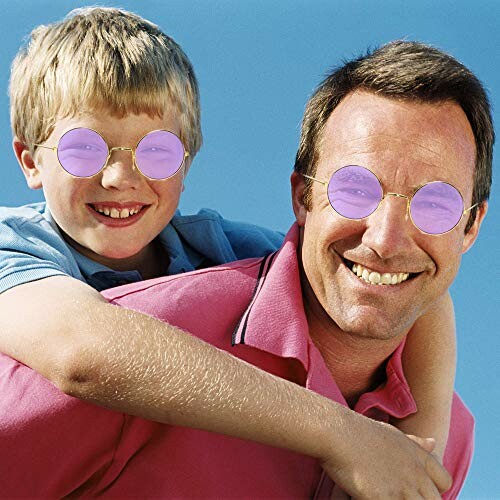 Father and son wearing round sunglasses smiling outdoors.