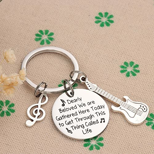 Keychain with guitar and music note charms, engraved with a message.