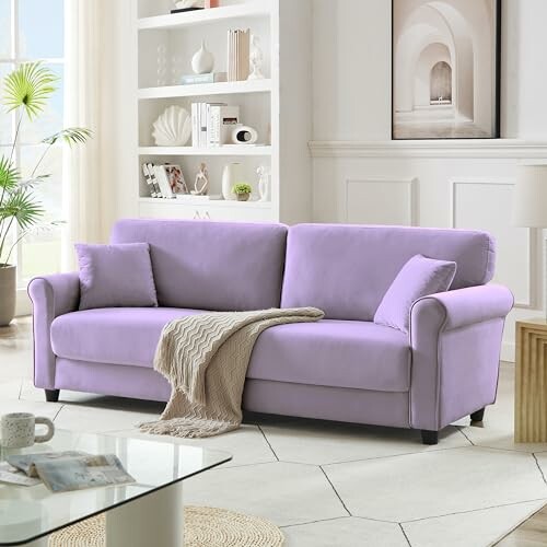 Modern living room with a purple sofa, cozy pillows, and a blanket.