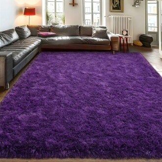 Purple fluffy rug in a modern living room with a black leather sofa and bright windows.