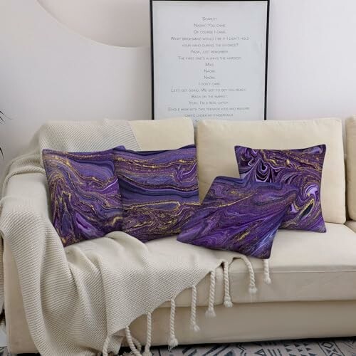 Sofa with purple marble pillows and a blanket.