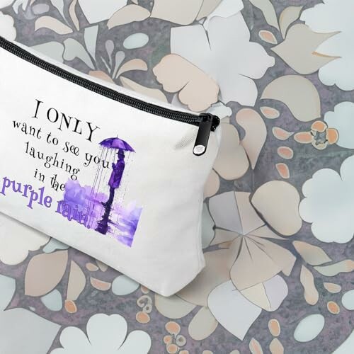 Pouch with 'I only want to see you laughing in the purple rain' text and umbrella illustration.