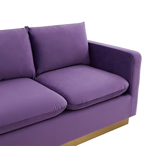 Purple sofa with cushions and gold base.