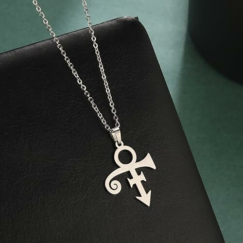 Silver symbol pendant necklace on a black surface